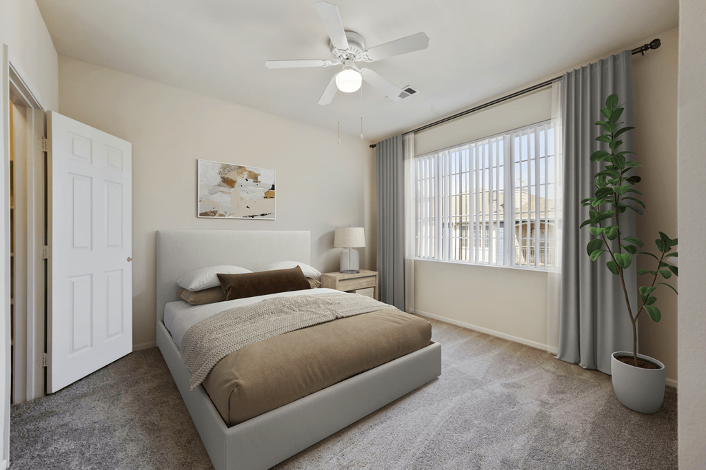 a bedroom with a large window and a ceiling fan