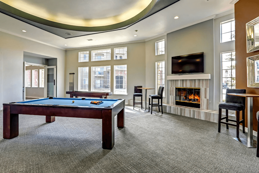 a games room with a pool table and a fireplace