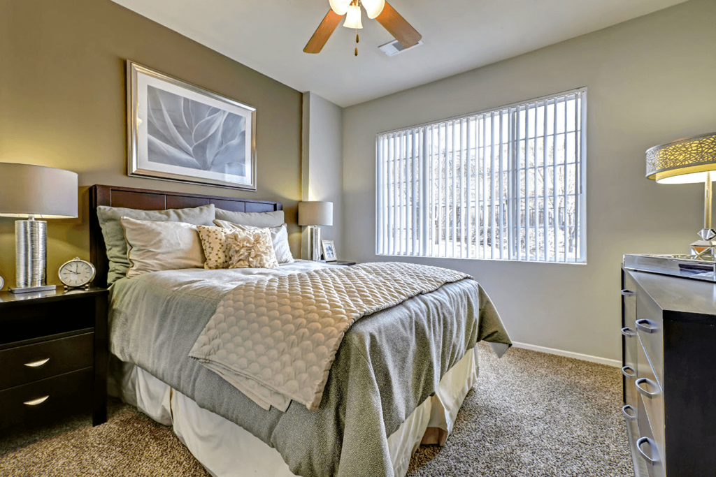 a bedroom with a large bed and a ceiling fan