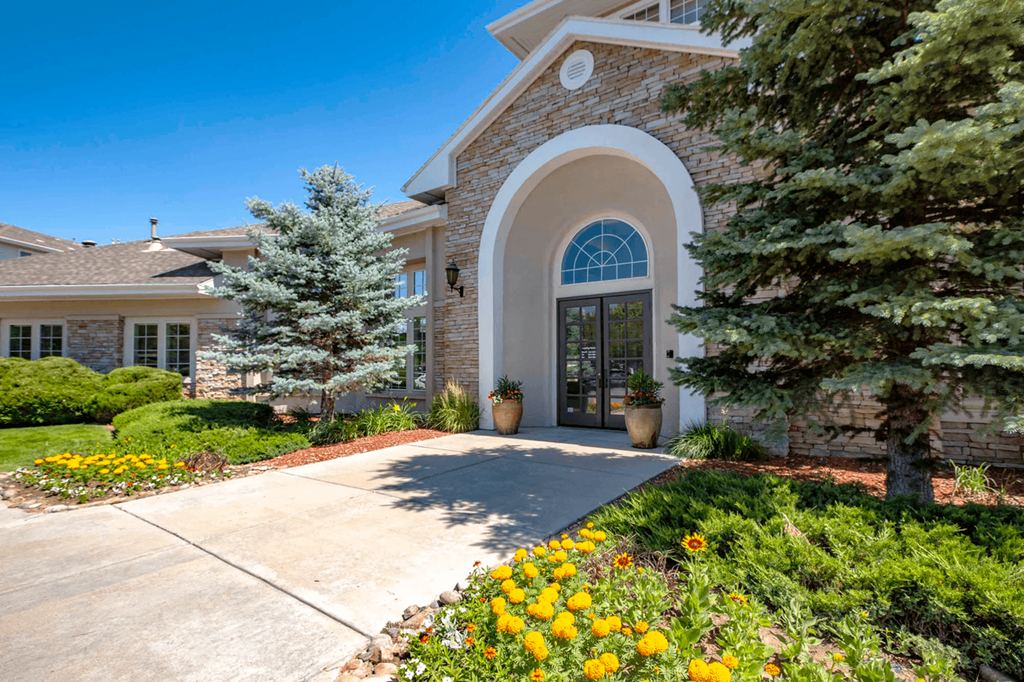 a house with a driveway and trees in front of it