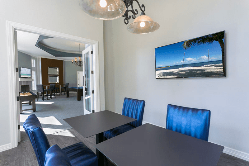 a dining room with a table and chairs and a tv on the wall