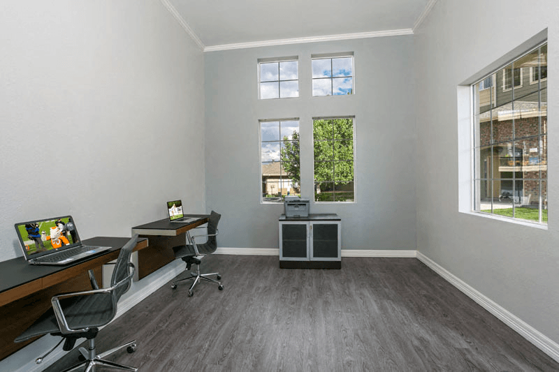 a room with two desks and two windows