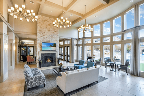 a resident clubhouse with a fireplace and large windows with sitting area