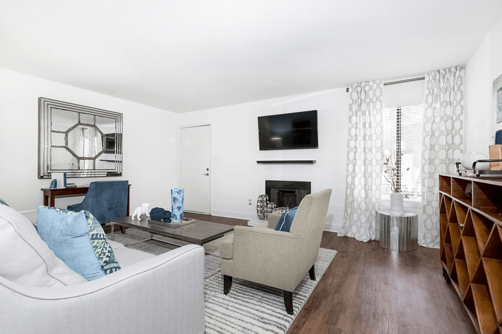 A living room with a white couch, a coffee table, and a fireplace at Regency Park Apartment Homes, Raleigh, NC