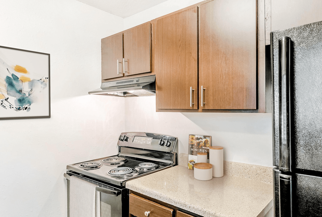 A kitchen with a stove, refrigerator, and cabinets at Regency Park Apartment Homes, Raleigh