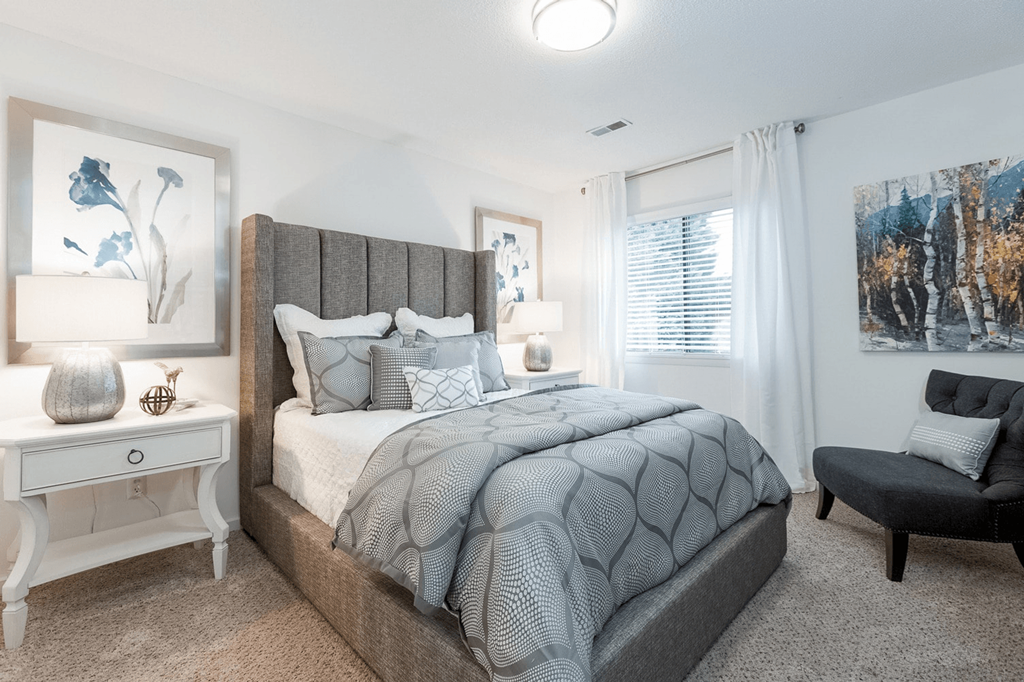 A bedroom with a large bed and a chair at Regency Park Apartment Homes, North Carolina