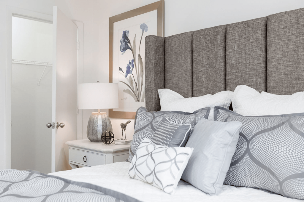 A bedroom with a bed, nightstand, and lamp at Regency Park Apartment Homes, Raleigh, NC, 27616