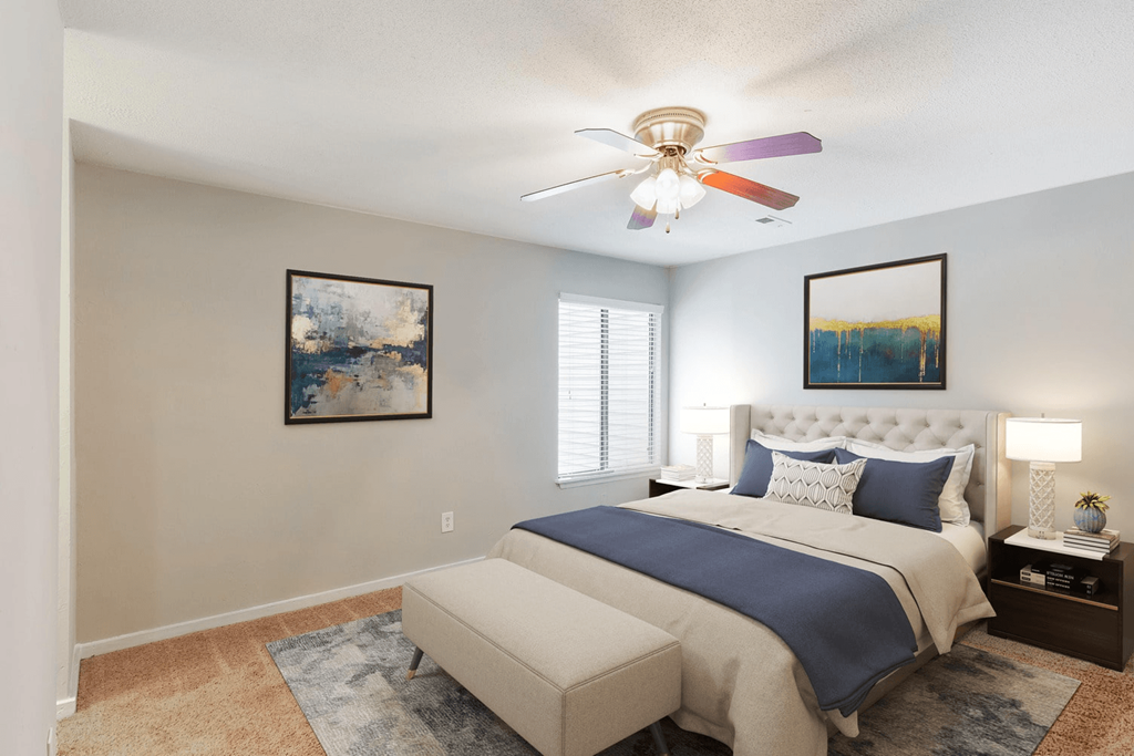 A bedroom with a bed, a bench, and two pictures on the wall at Regency Park Apartment Homes, Raleigh, 27616