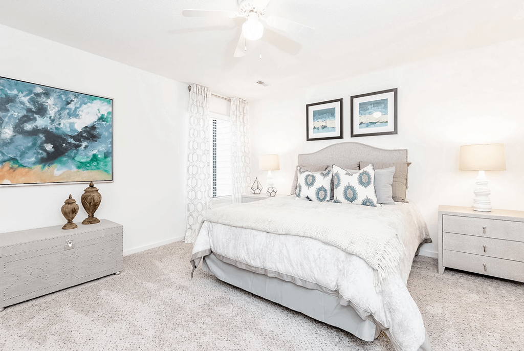 A bedroom with a large bed, a ceiling fan, and a painting on the wall at Regency Park Apartment Homes, North Carolina, 27616