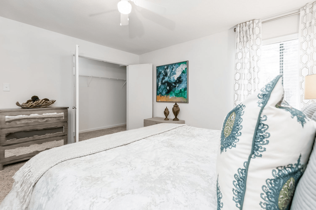 A bedroom with a large bed and a painting on the wall at Regency Park Apartment Homes, Raleigh, NC, 27616