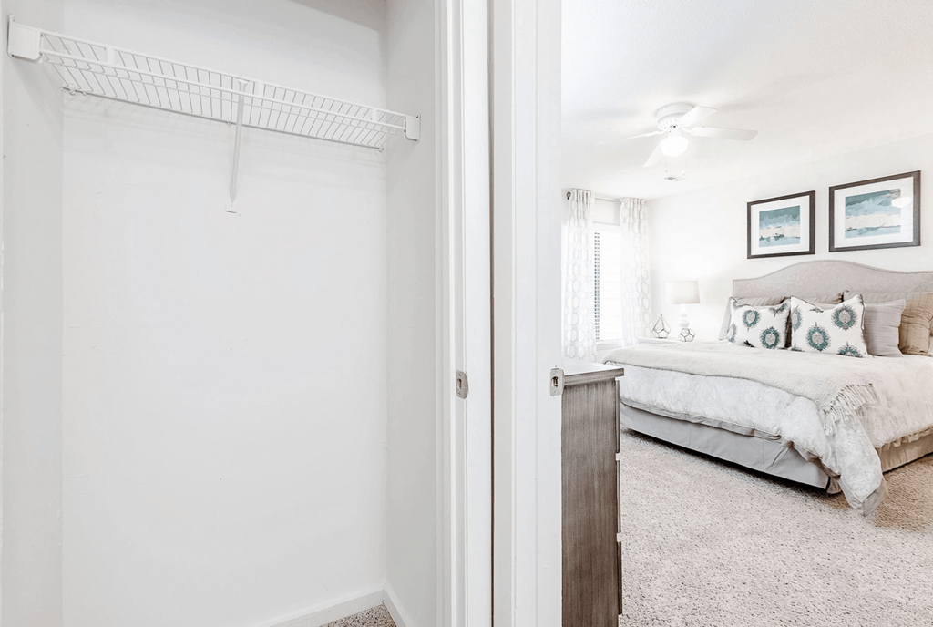 A white bedroom with a bed and a white wall at Regency Park Apartment Homes, Raleigh, NC