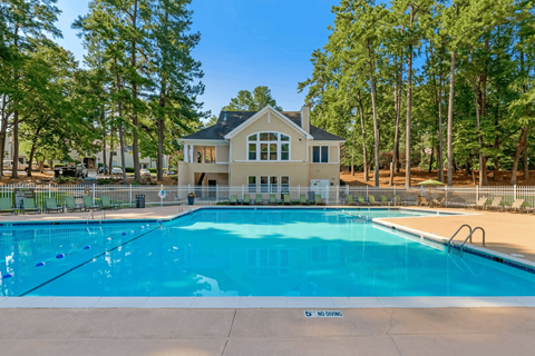 A large swimming pool in front of a house.