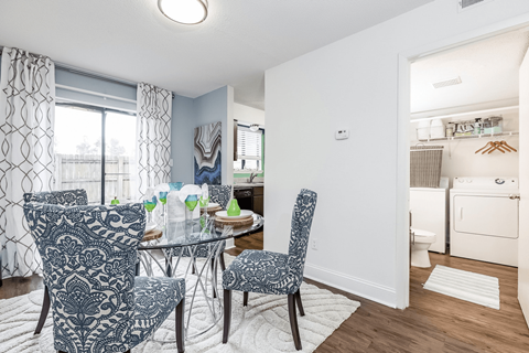 A dining room with a table set for four.