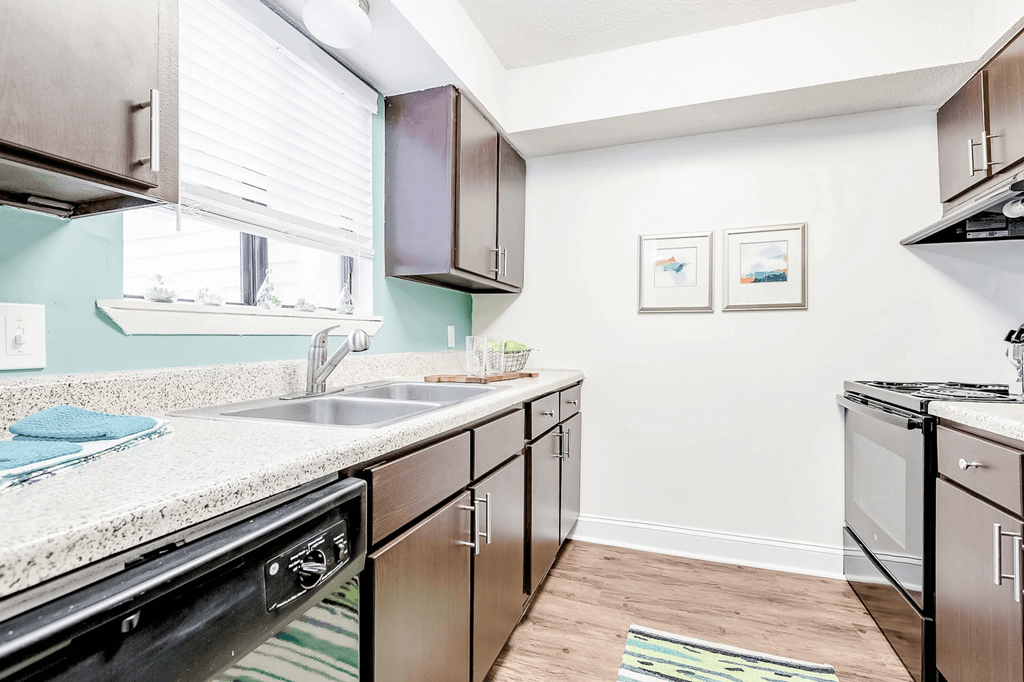 A kitchen with a sink, stove, and cabinets at Regency Park Apartment Homes, North Carolina