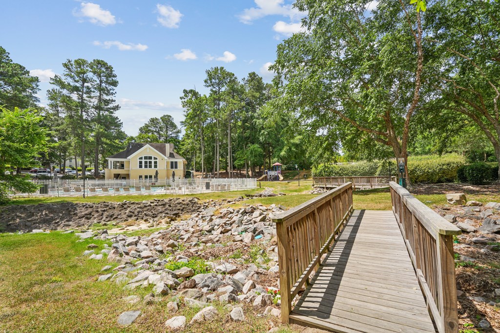 A wooden bridge leads to a house surrounded by trees at Regency Park Apartment Homes, Raleigh