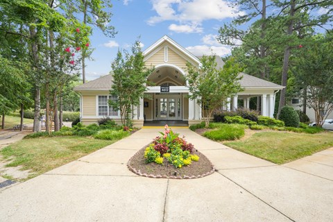A house with a front yard and a flower bed in front of it.