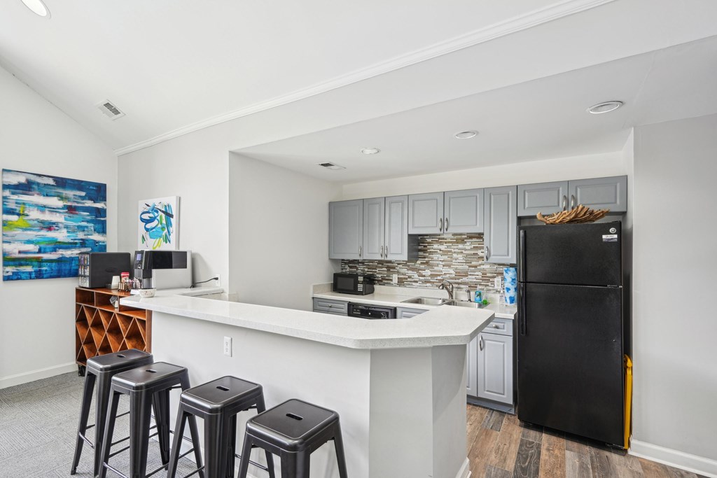 A kitchen with a black fridge and white countertops at Regency Park Apartment Homes, Raleigh, 27616