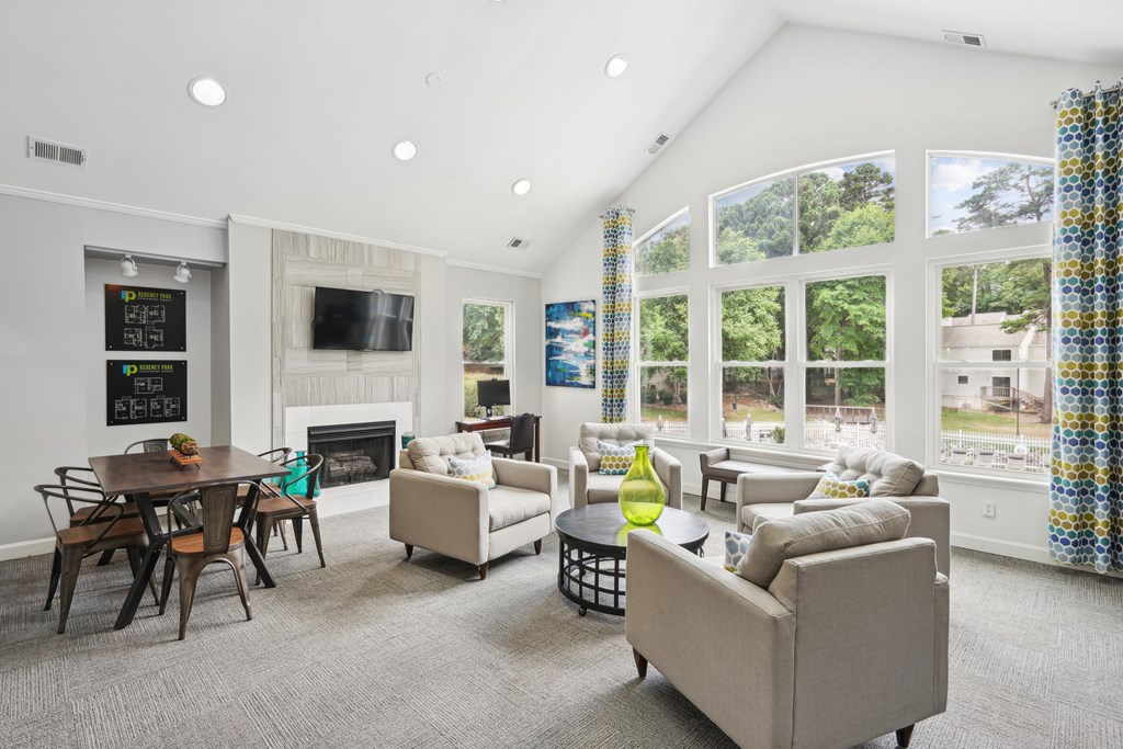 A living room with a fireplace and a dining table at Regency Park Apartment Homes, North Carolina