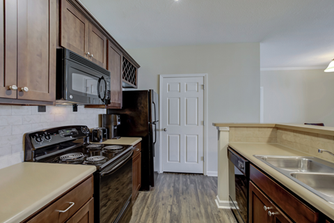 A kitchen with dark wood cabinets and a white door in the background.