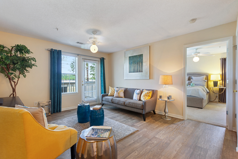 A living room with a yellow chair and a grey couch.
