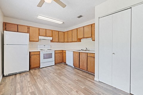 A kitchen with wooden cabinets and a white fridge.