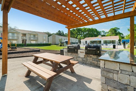 Picnic able under pergola with 2 BBQ gills and cooking island