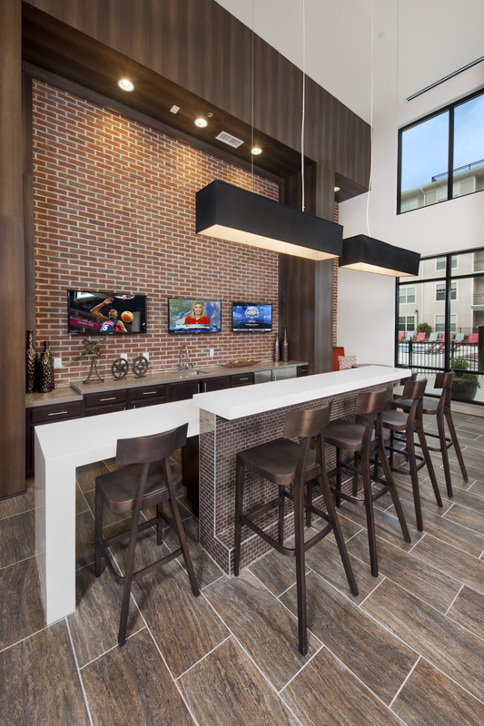 Resident lounge area facing a bar and kitchen space for entertaining