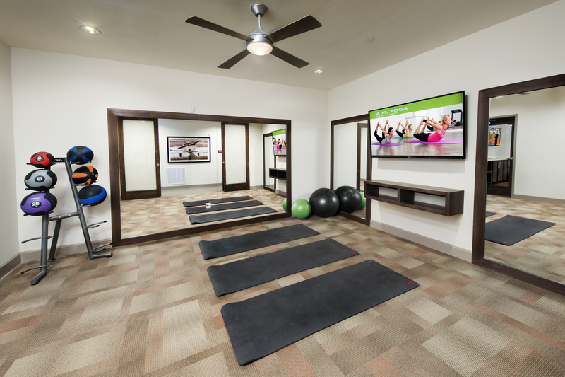 Resident yoga room facing yoga mats and television