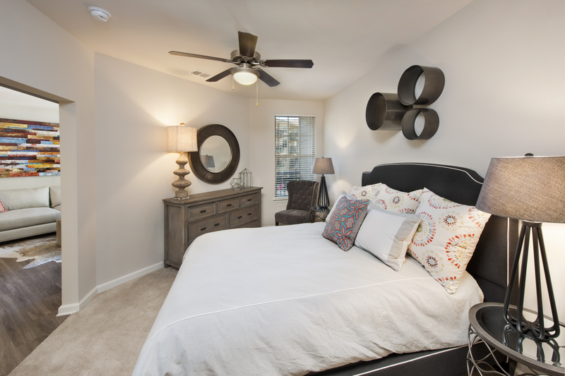 Bedroom facing a bed, two nightstands and a dresser facing into