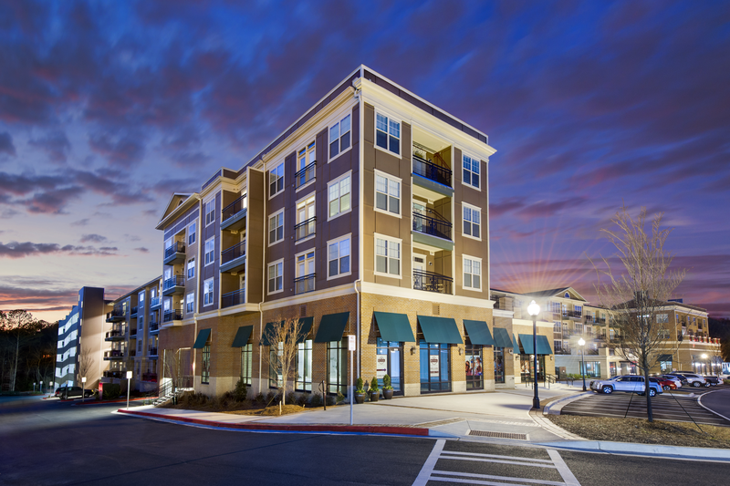 Nighttime view of retail space and exterior of the apartment building