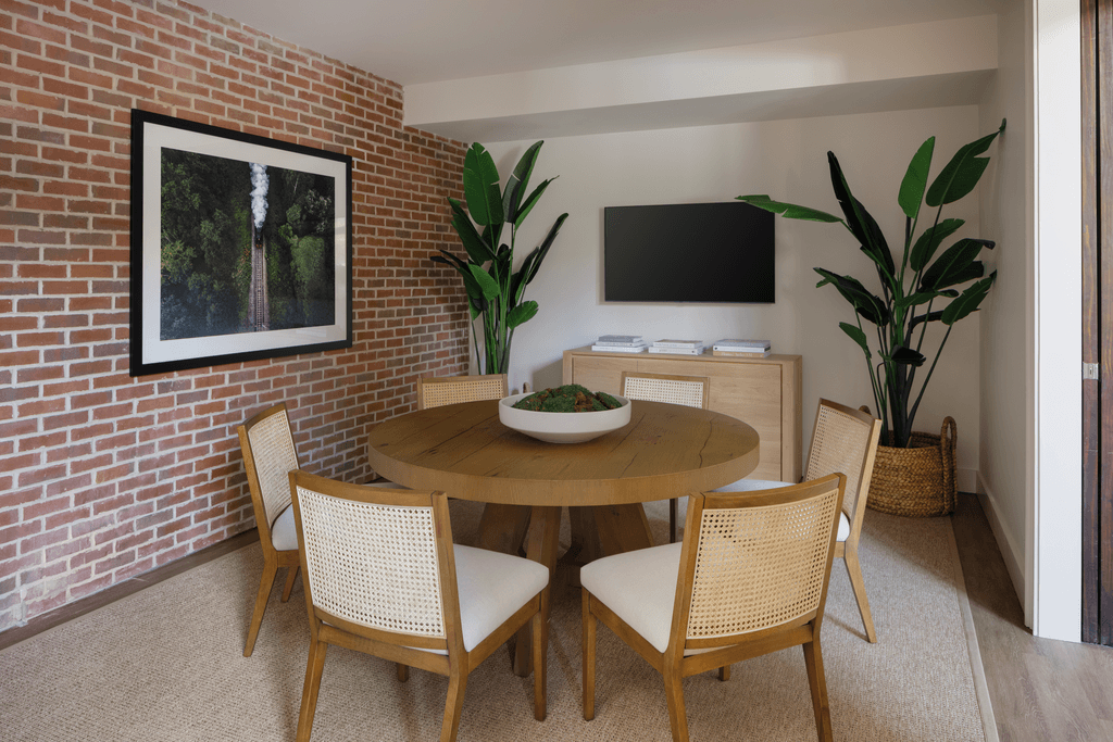a dining room with a brick wall and a table and chairs