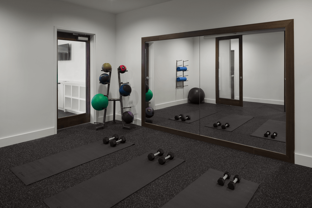 a fitness room with mirrors and exercise equipment