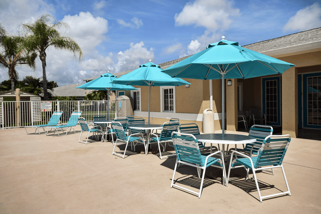 a patio with blue chairs and umbrellas