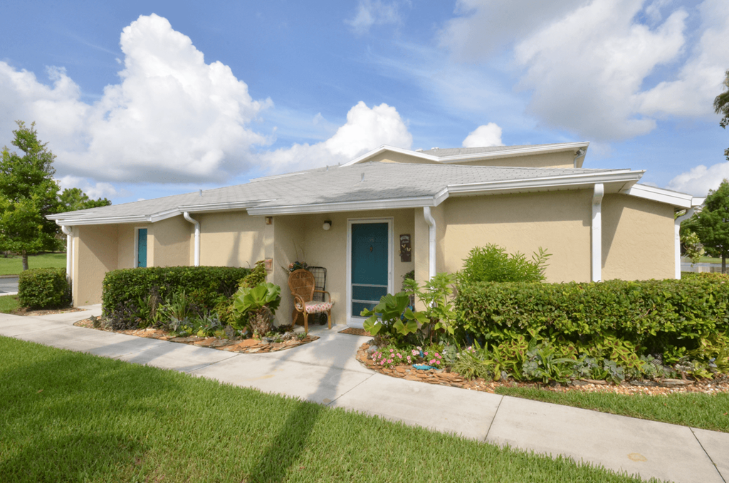 a house with a blue door and a sidewalk in front of it