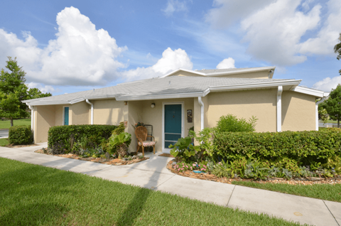 a house with a blue door and a sidewalk in front of it