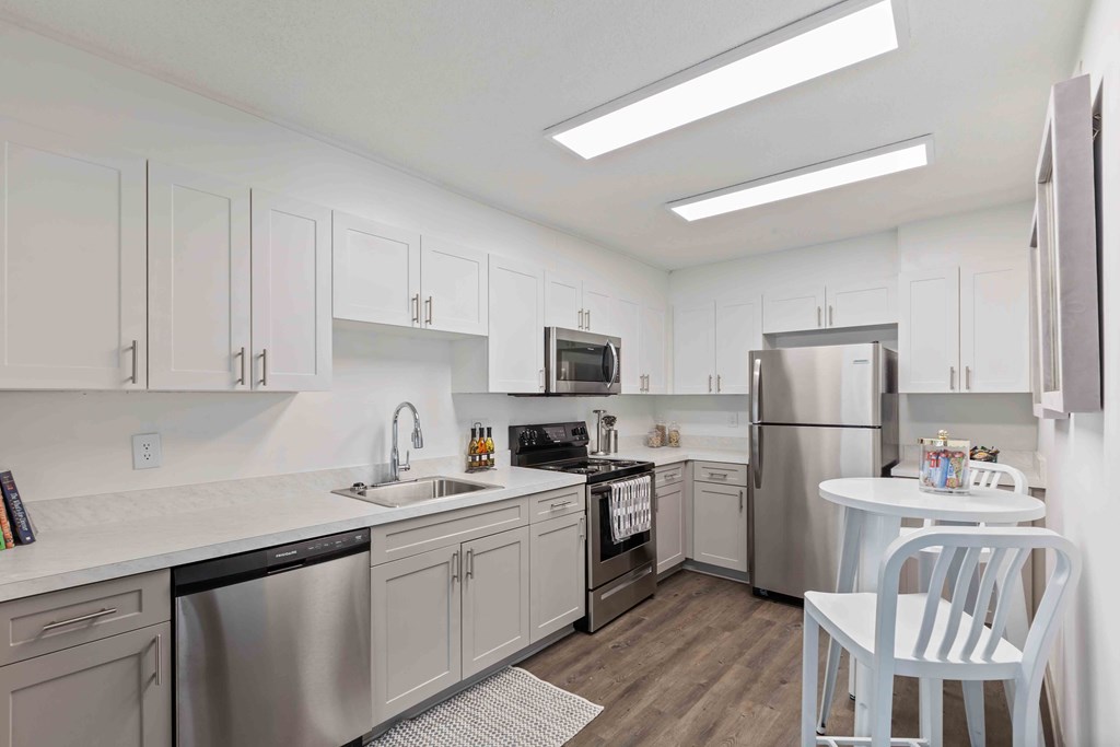 A kitchen with white cabinets and stainless steel appliances.