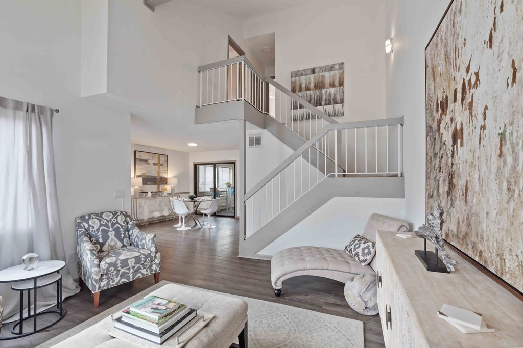A living room with a staircase and a chair.