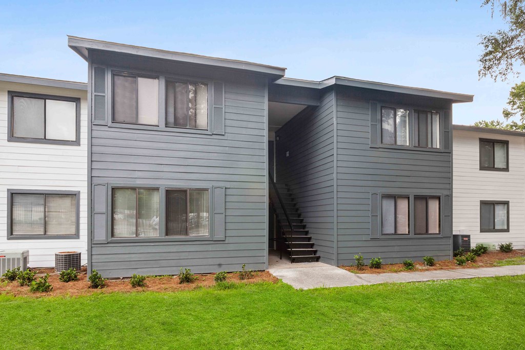 A modern two-story house with a grey exterior and a small front yard.