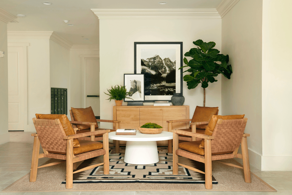 a living room with a table and chairs and a plant