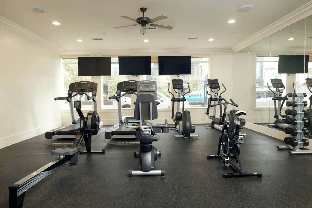 a gym with treadmills and weights on the floor