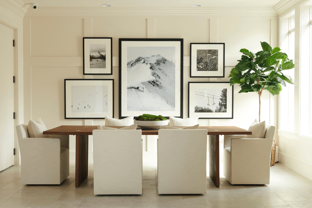 a dining room with a table and chairs and pictures on the wall