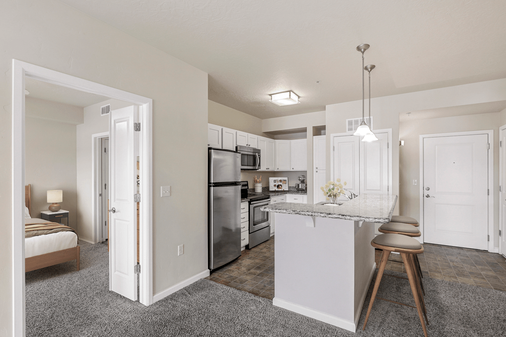 a spacious kitchen with white cabinets and stainless steel appliances