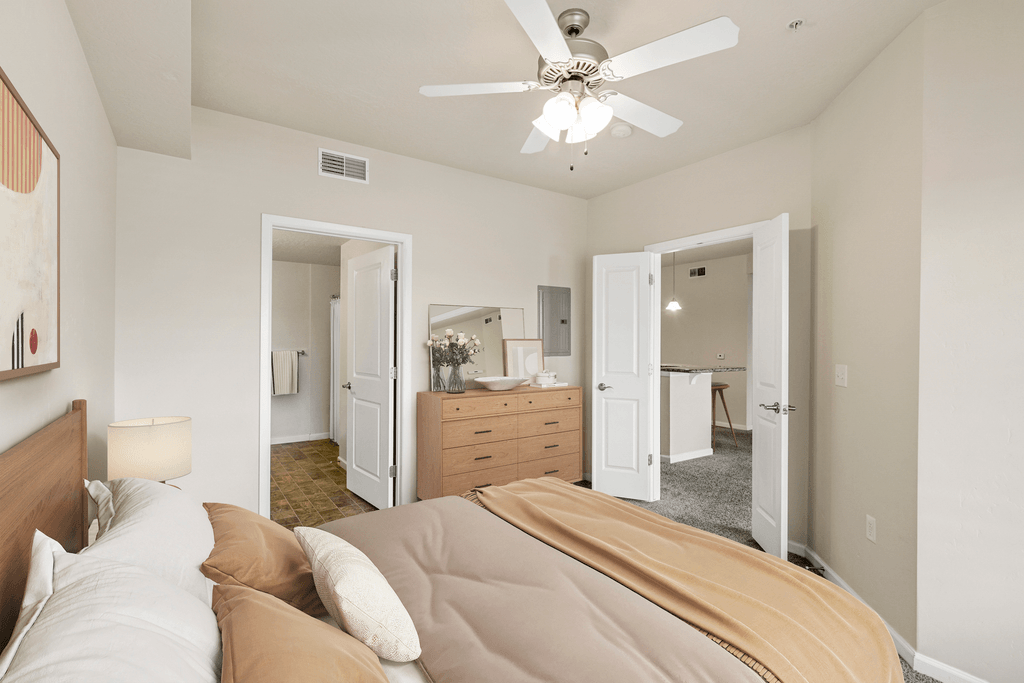 a bedroom with a large bed and a ceiling fan