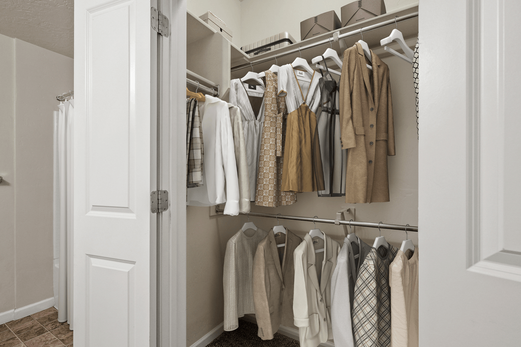 a closet with a rack of clothes and a door