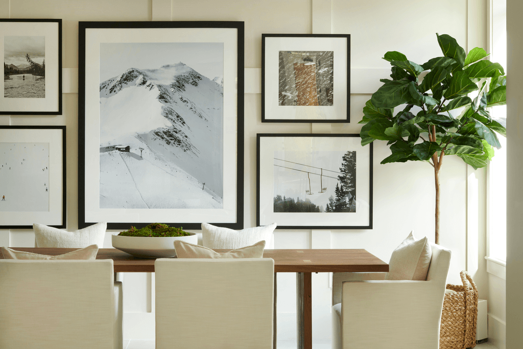 a dining room with pictures on the wall and a table with chairs