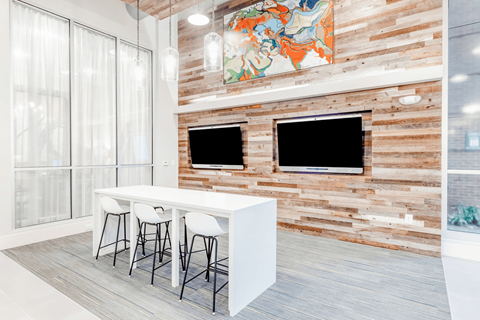 a dining room with a white table and chairs and a television on the wall