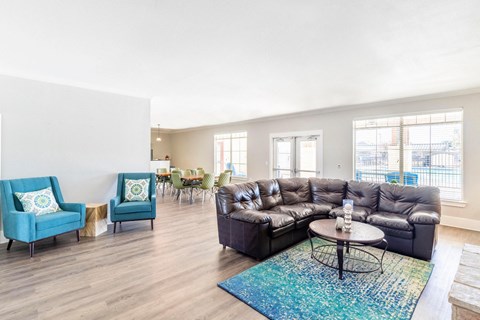 A living room with a blue couch and a black couch.