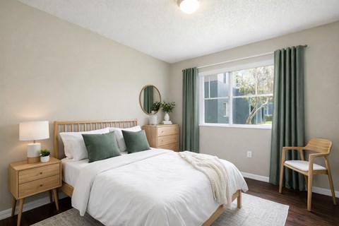 A bedroom with a bed, nightstand, and chair.
