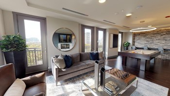 Resident sky lounge facing a table and sitting area complete with a television and fireplace. - Photo Gallery 65