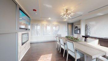 Resident sky lounge facing a table and sitting area complete with a television and fireplace. - Photo Gallery 53
